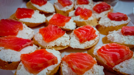 Small canapes with cottage cheese and a piece of salted salmon.