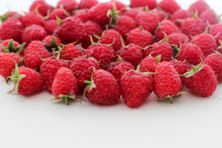 Few ripe raspberries in a white background with a copy space