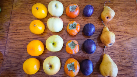 Fruit background. Apples, oranges, pears, persimmons, plums.