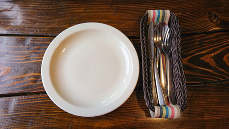 Empty White Plate and cutlery are on the tableの写真素材