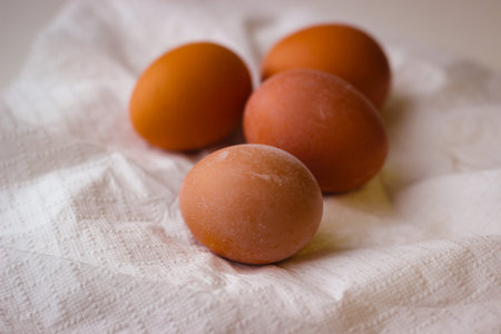 Four red chicken eggs on a white paper napkin