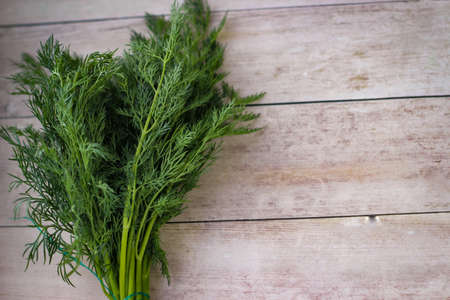 Green dill leaves on a wooden backgroundの写真素材