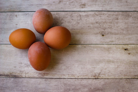 Four red chicken eggs on a wooden background