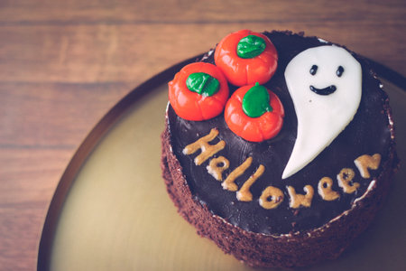 Halloween Concept - Delicious chocolate cake on Halloween with pumpkins, ghost and inscription...