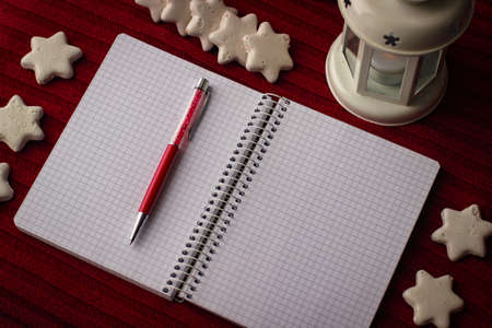 Flat lay and mockup on the Christmas theme. Top view of white notebook, red pen and decor on red fabric.の写真素材