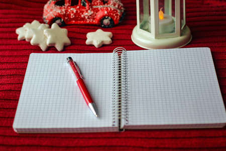 Flat lay and mockup on the Christmas theme. Top view of white notebook, red pen and decor on red fabric.の写真素材