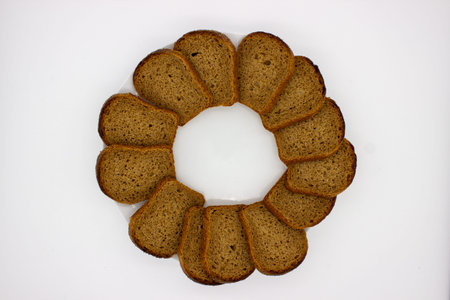 Slices of the rye bread is laid out in circle on white background
