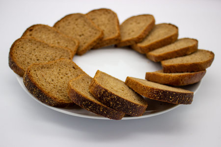 Slices of the rye bread is laid out in circle on white background