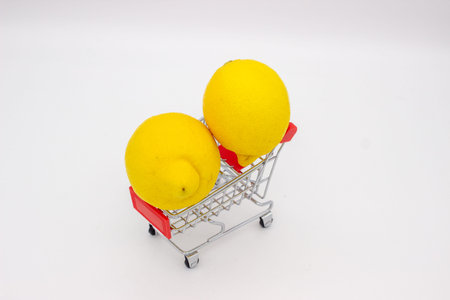 Two lemons in metal store trolley on white backgroundの写真素材