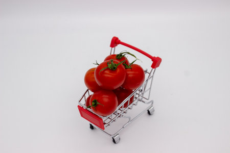 Tomatoes in metal basket on white background. isolated imageの写真素材