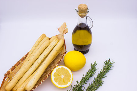 Traditional Italian food. Bread sticks grissinni, lemons, olive oil, spruce branch.