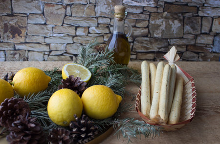 Traditional Italian food. Bread sticks grissinni, lemons, olive oil, spruce branch.