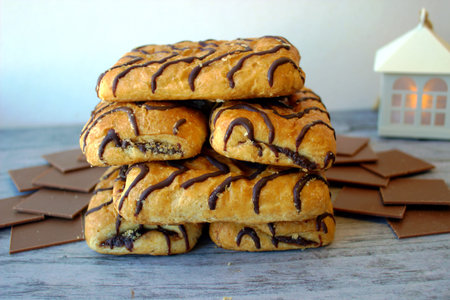 Wonderful biscuit cakes poured with chocolate stand on wooden background