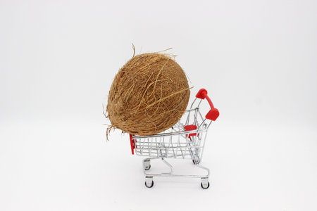 Coconut on metal shopping cart on white background