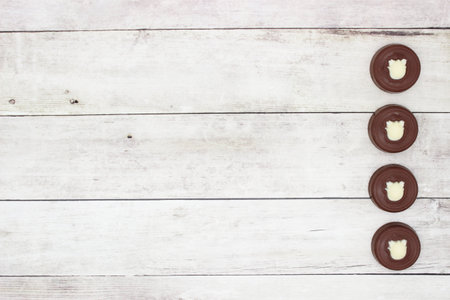 Four chocolates on light-gray wooden background.の写真素材