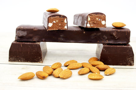 Chocolate bars with almonds on white wooden background. selective focus.の写真素材
