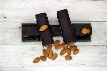Chocolate bars with almonds on white wooden background. top view.の写真素材