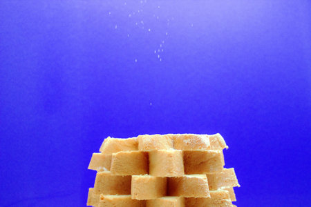 National Italian Christmas dessert Panettone on blue background sprinkled with powdered sugar