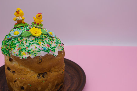 A traditional Easter cake topped with white icing, colorful sprinkles, and cute sugar decorations of chicks and flowers. The pastel background enhances the festive and joyful holiday moodの写真素材