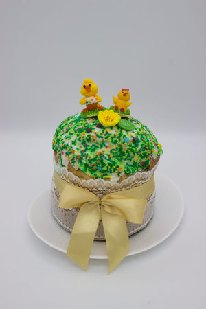 Traditional Easter cake with icing, colorful sprinkles, and sugar figures of chicks, wrapped in lace...