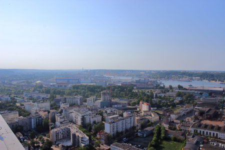 Aerial panoramic view of an industrial coastal city with residential buildings, shipyards, and...