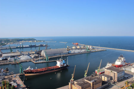 Aerial view of seaport with cargo ships, cranes, and storage facilities on a sunny summer day by the...