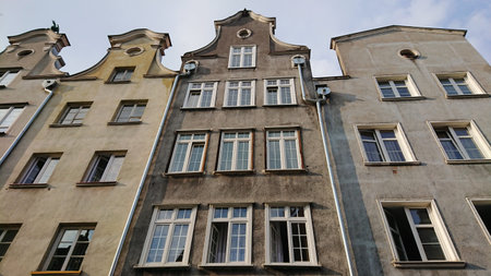 GDANSK, POLAND - JUNE 07, 2019: Front view of historic tenement house facades with decorative...