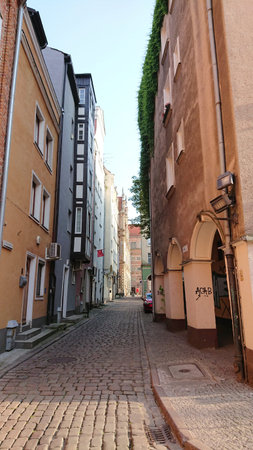 Gdansk, Poland. June 07, 2019. Narrow cobblestone street lined with historic townhouses in the old...