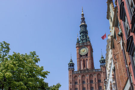 Gdansk, Poland. June 07, 2019. Historic town hall tower rising above colorful old town street...