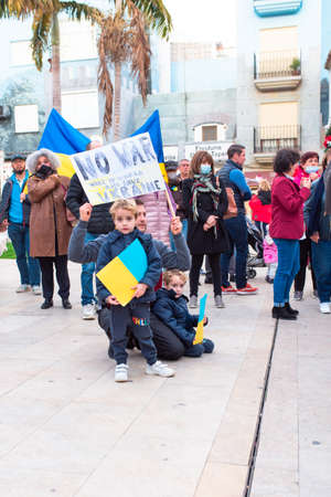 Estepona, Andalusia, Spain -  March. 05, 2022. Protestors rally in support of Ukraine against russian agression. Anti-war demonstration. Father with kids is holding picket banner 'No war!"のeditorial素材