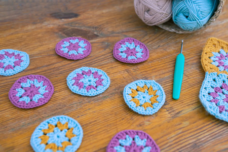 Side view of small round crochet patterns with selected focus on wooden surface, blurred crochet...