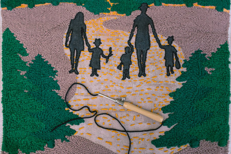 Top view of punch needle with black thread lying on a piece of embroidery - two adults and three...