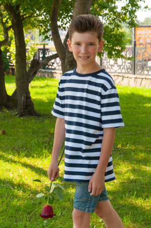 a young romantic boy with a fashionable hairstyle and a roseの写真素材