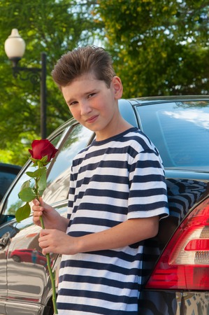 a young romantic boy with a fashionable hairstyle and a roseの写真素材