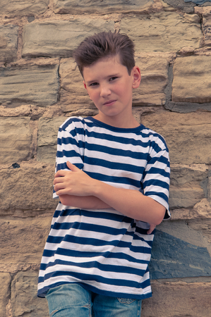 stylish young guy on stone wall backgroundの写真素材
