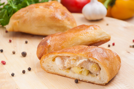 small pie with chicken and potatoes on a wooden Board. Close up. Decorated with vegetables and herbs.の写真素材