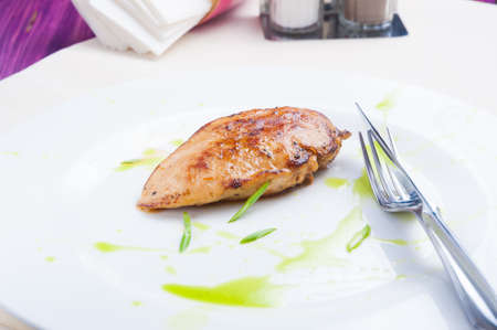 tasty grilled fried chicken fillet on a white plateの写真素材