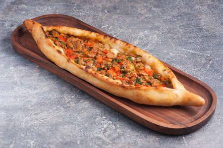 tasty pide with meat and vegetables on a wooden Board. Turkish cuisineの写真素材