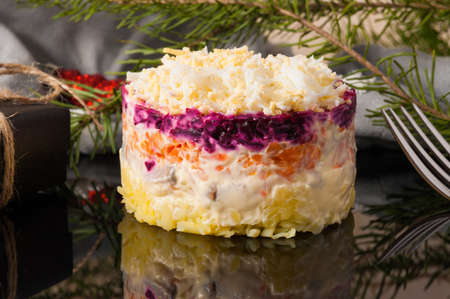 tasty herring salad under a fur coat on a black background. Close upの写真素材