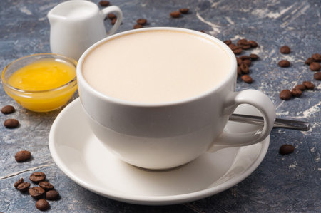 coffee with milk and honey on a gray background with coffee beansの写真素材