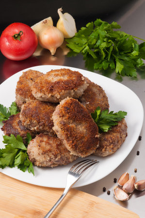 tasty fried meat cutlets decorated with vegetables and herbs