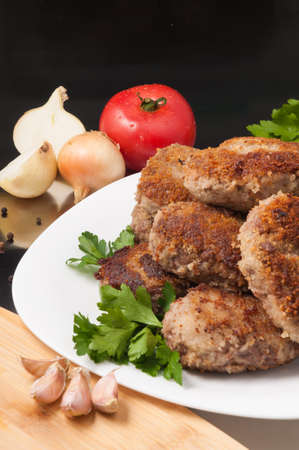 tasty fried meat cutlets decorated with vegetables and herbsの写真素材