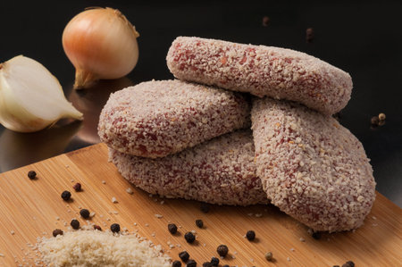 tasty raw pork cutlets with onion in breadcrumbs
