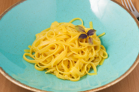 tasty homemade pasta in a plate decorated with Basil. close up