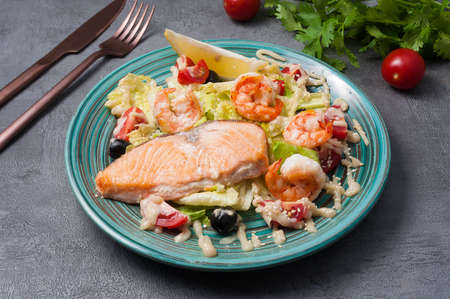 tasty salad with salmon, shrimp and vegetables on a gray backgroundの写真素材