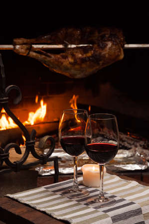 tasty back of a lamb on a spit with a glass of brandyの写真素材