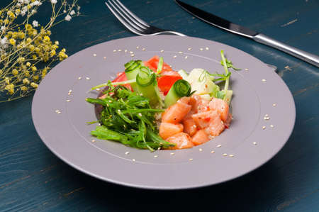 tasty poke with salmon and vegetables decorated with sesame seedsの写真素材