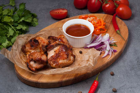tasty chicken kebab with tomato sauce on a wooden boardの写真素材