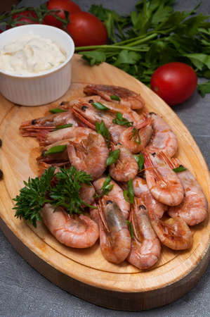 tasty boiled shrimp with garlic sauce on a wooden boardの写真素材