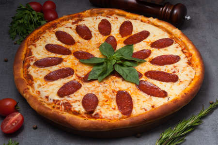 tasty pepperoni pizza with mozzarella cheese decorated with basilの写真素材